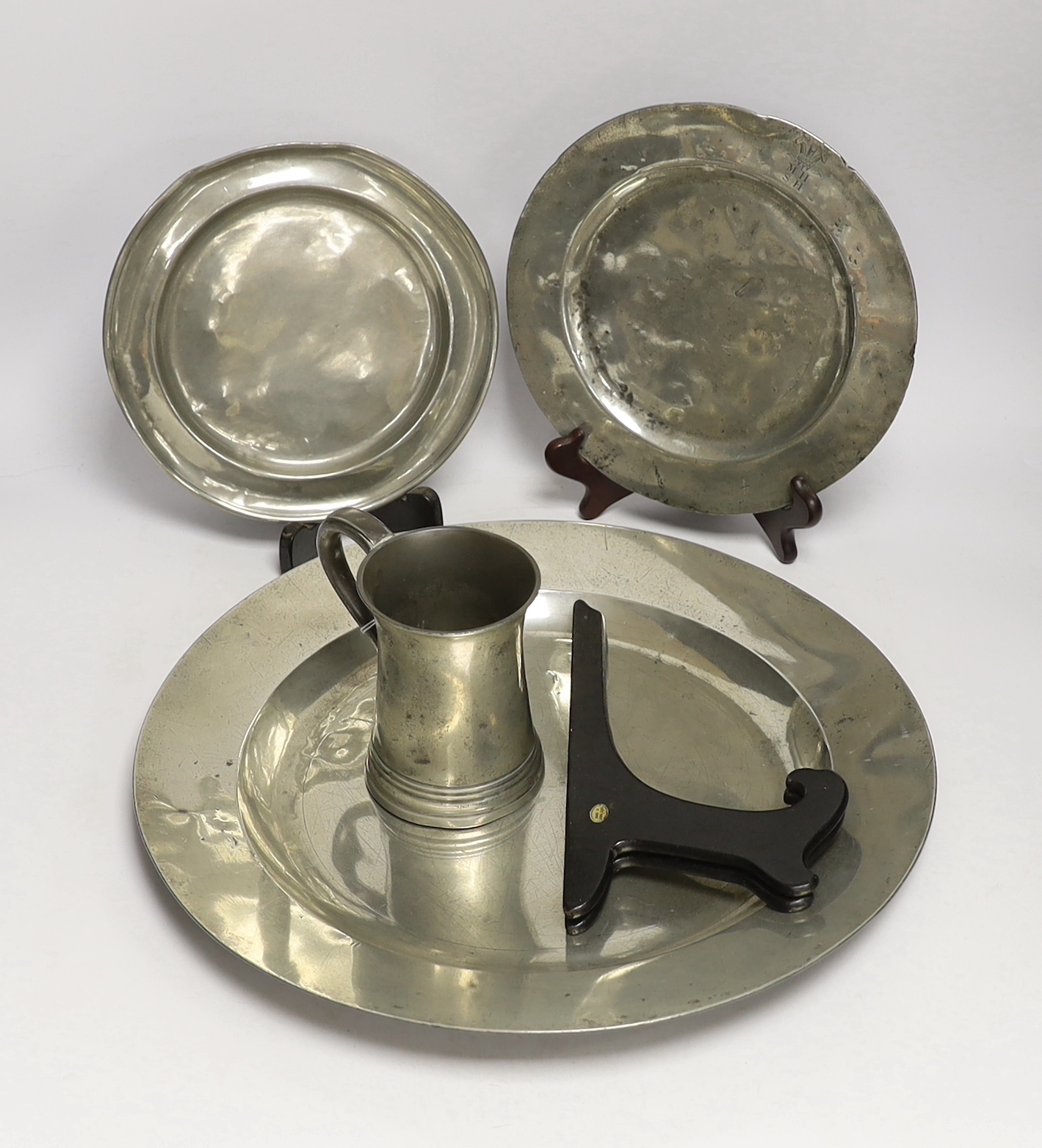 Four 18th century and later pewterware items including a charger, 41.5cm diameter, two plates, and a mug